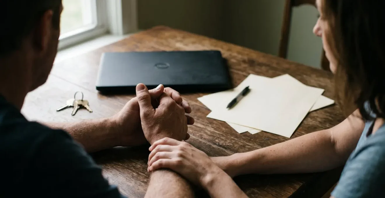 Représentation du stress financier d'un couple face aux charges immobilières et au calcul du reste à vivre.
